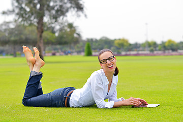 Image showing Beautiful young woman with  tablet in park