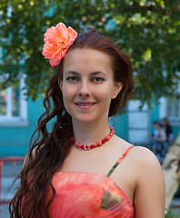 Image showing Portrait of a girl in a pink dress with a flower in her hair