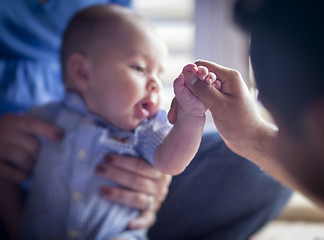 Image showing Cute Mixed Race Infant Boy Holds Father's Thumb