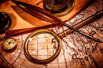 Image showing Vintage magnifying glass lies on an ancient world map