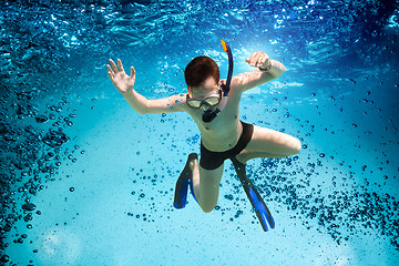 Image showing Teenager in the mask and snorkel swim underwater.