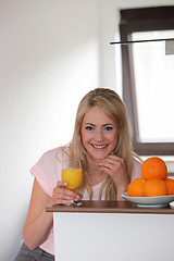 Image showing Smiling woman drinking orange juice