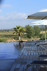 Image showing Recliners and beach umbrellas poolside