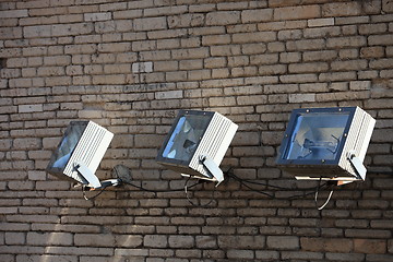 Image showing Three spotlights on a brick wall
