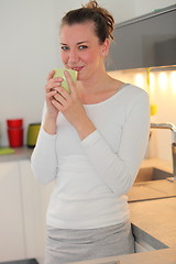 Image showing Housewife drinking coffee in her kitchen