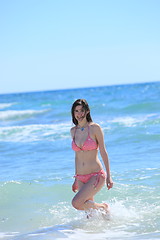 Image showing Beautiful woman in a bikini standing in the surf