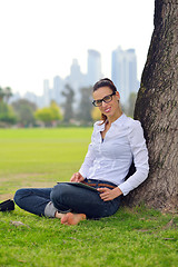 Image showing Beautiful young woman with  tablet in park