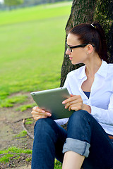 Image showing Beautiful young woman with  tablet in park