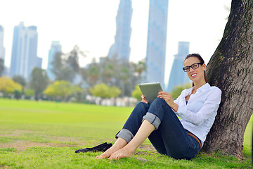 Image showing Beautiful young woman with  tablet in park