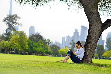 Image showing Beautiful young woman with  tablet in park