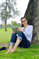 Image showing Beautiful young woman with  tablet in park