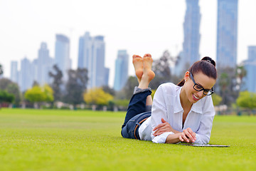 Image showing Beautiful young woman with  tablet in park