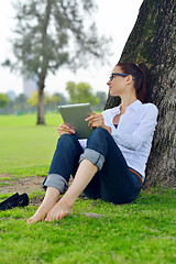 Image showing Beautiful young woman with  tablet in park