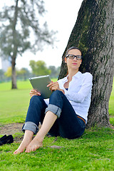 Image showing Beautiful young woman with  tablet in park