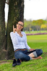 Image showing Beautiful young woman with  tablet in park