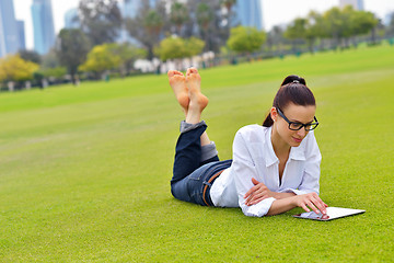 Image showing Beautiful young woman with  tablet in park