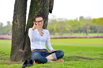 Image showing Beautiful young woman with  tablet in park