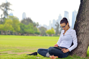 Image showing Beautiful young woman with  tablet in park