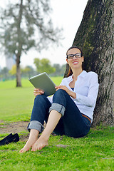 Image showing Beautiful young woman with  tablet in park