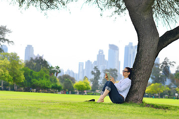 Image showing Beautiful young woman with  tablet in park