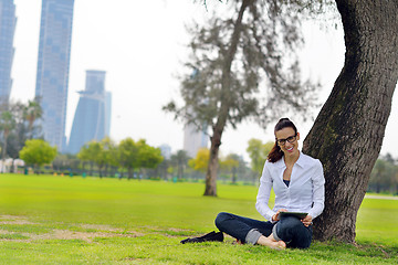 Image showing Beautiful young woman with  tablet in park