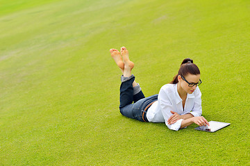 Image showing Beautiful young woman with  tablet in park