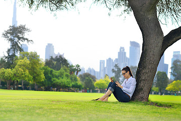 Image showing Beautiful young woman with  tablet in park