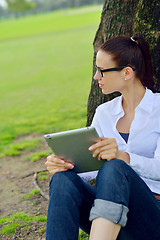 Image showing Beautiful young woman with  tablet in park