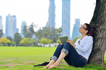 Image showing Beautiful young woman with  tablet in park