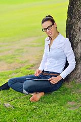 Image showing Beautiful young woman with  tablet in park