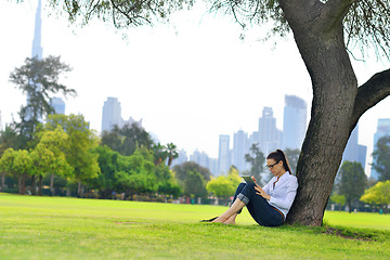 Image showing Beautiful young woman with  tablet in park