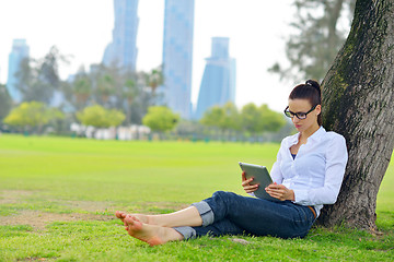 Image showing Beautiful young woman with  tablet in park