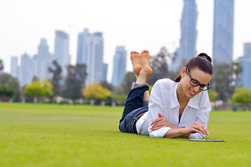 Image showing Beautiful young woman with  tablet in park