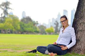 Image showing Beautiful young woman with  tablet in park