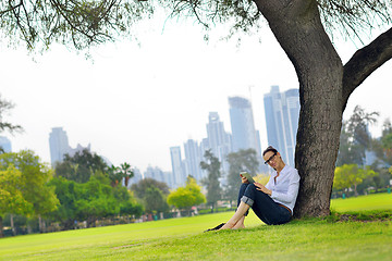 Image showing Beautiful young woman with  tablet in park