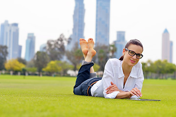 Image showing Beautiful young woman with  tablet in park