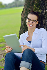 Image showing Beautiful young woman with  tablet in park