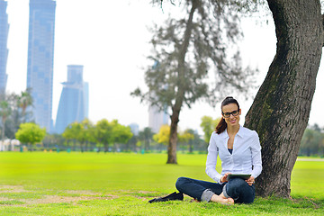 Image showing Beautiful young woman with  tablet in park