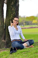 Image showing Beautiful young woman with  tablet in park