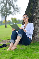 Image showing Beautiful young woman with  tablet in park