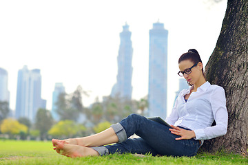 Image showing Beautiful young woman with  tablet in park