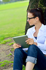 Image showing Beautiful young woman with  tablet in park