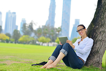 Image showing Beautiful young woman with  tablet in park