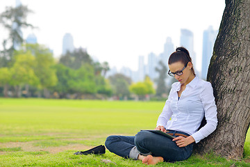 Image showing Beautiful young woman with  tablet in park