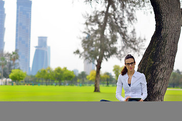 Image showing Beautiful young woman with  tablet in park