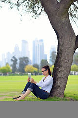 Image showing Beautiful young woman with  tablet in park