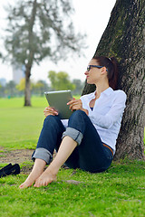 Image showing Beautiful young woman with  tablet in park