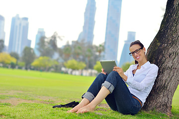 Image showing Beautiful young woman with  tablet in park