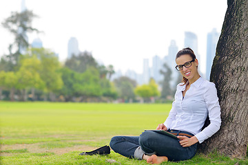 Image showing Beautiful young woman with  tablet in park