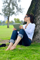 Image showing Beautiful young woman with  tablet in park